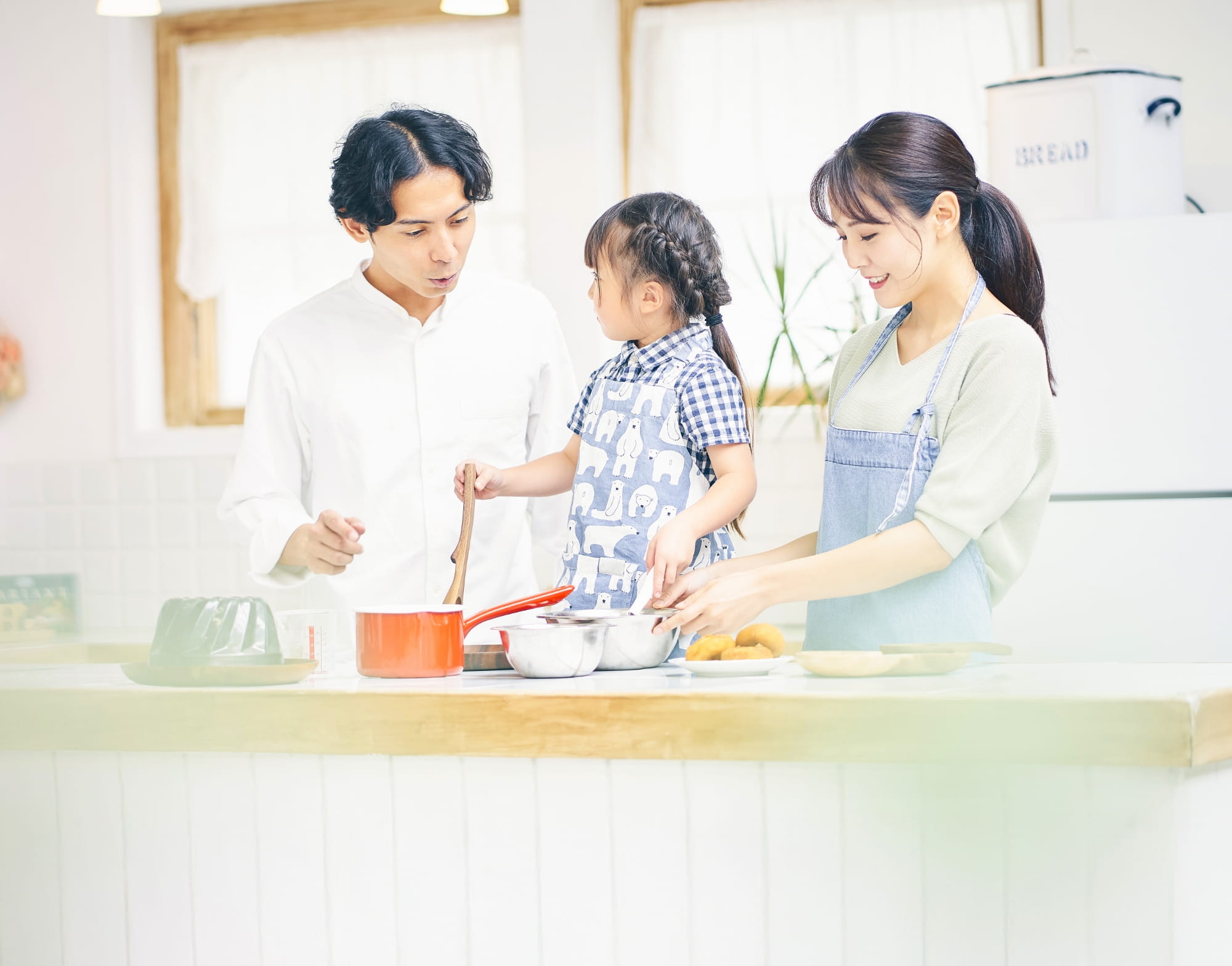 家族3人がキッチンで一緒に料理をしている様子