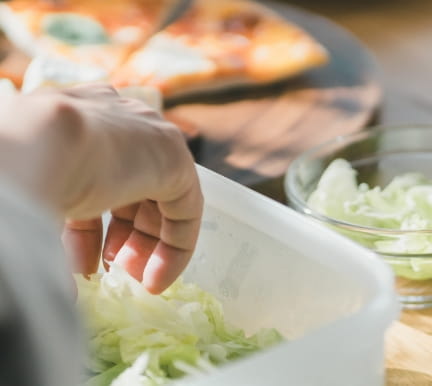 人が容器にレタスを入れている様子