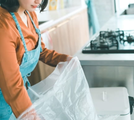 キッチンでプラスチック袋を持つ女性の画像