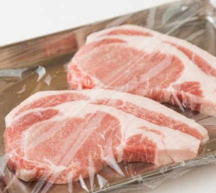 プラスチックラップで包まれた生の豚肉のチョップ